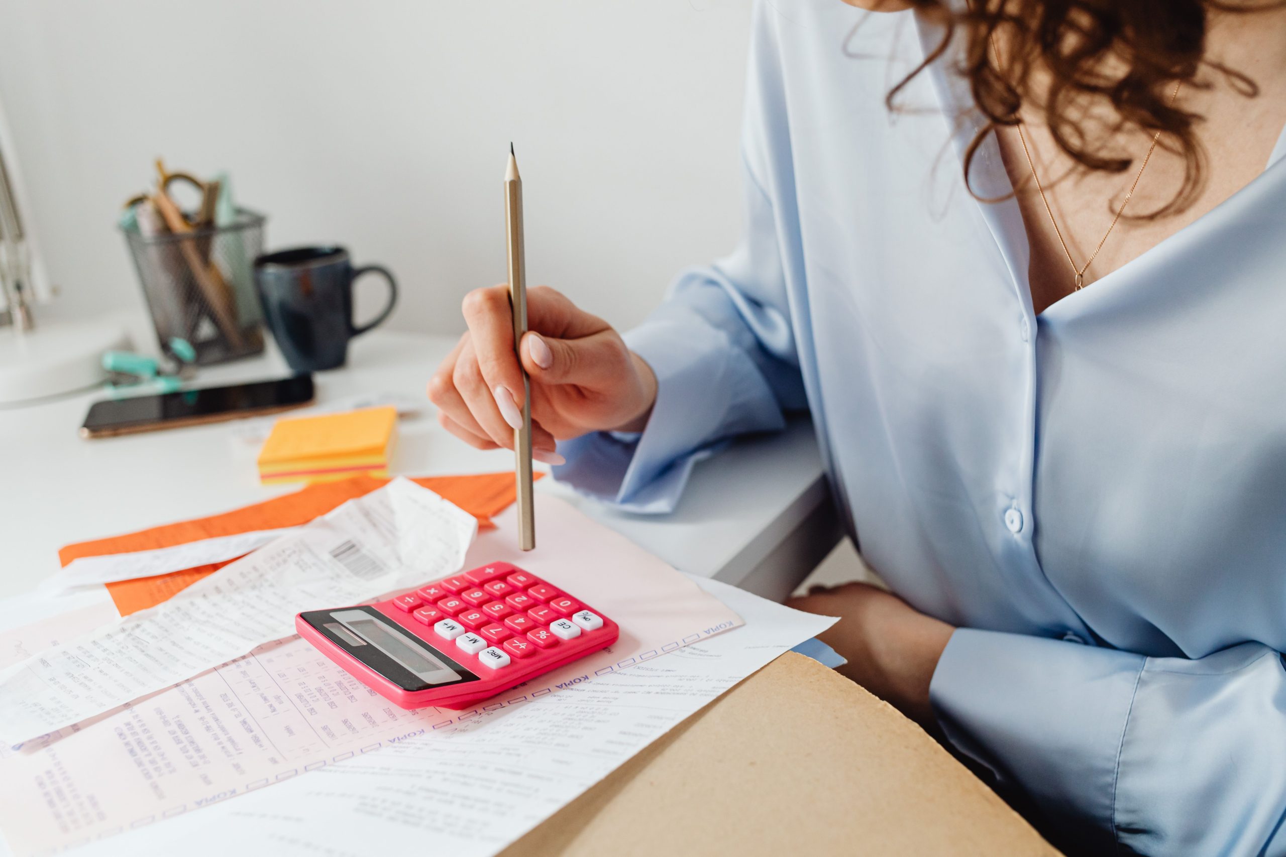 Femme calculant des dépenses avec papiers et calculatrice