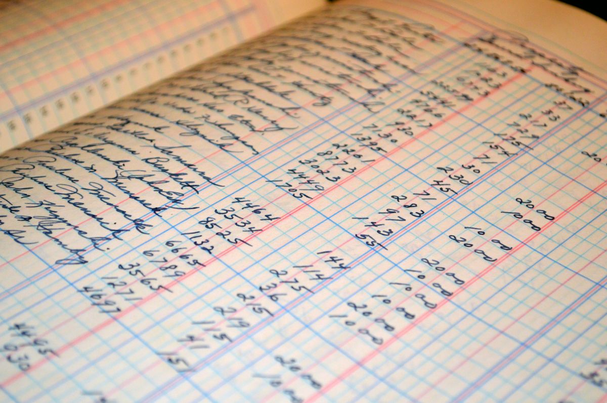 Grand livre de comptes tenu à la main