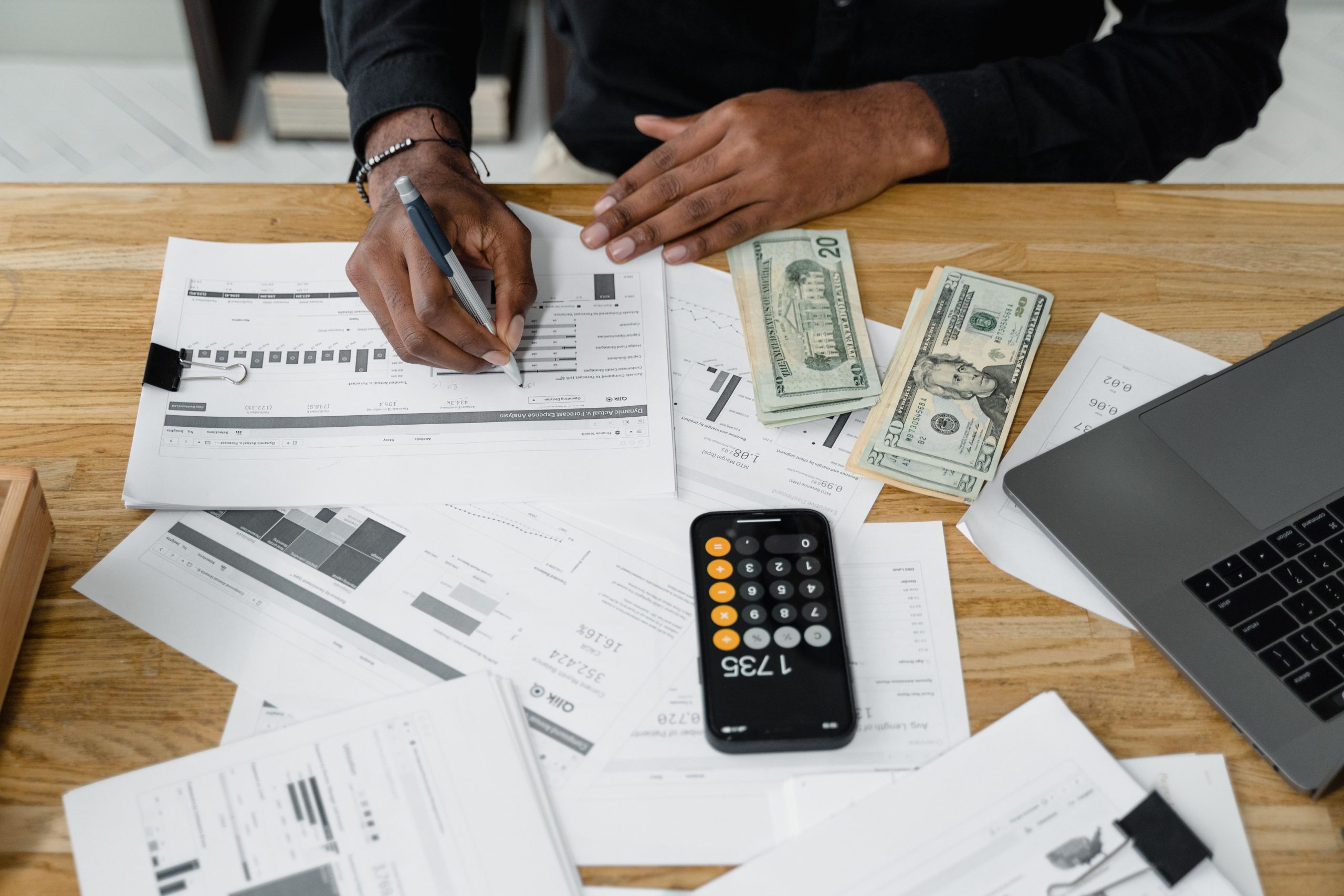 Homme travaillant sur des rapports financiers avec calculatrice