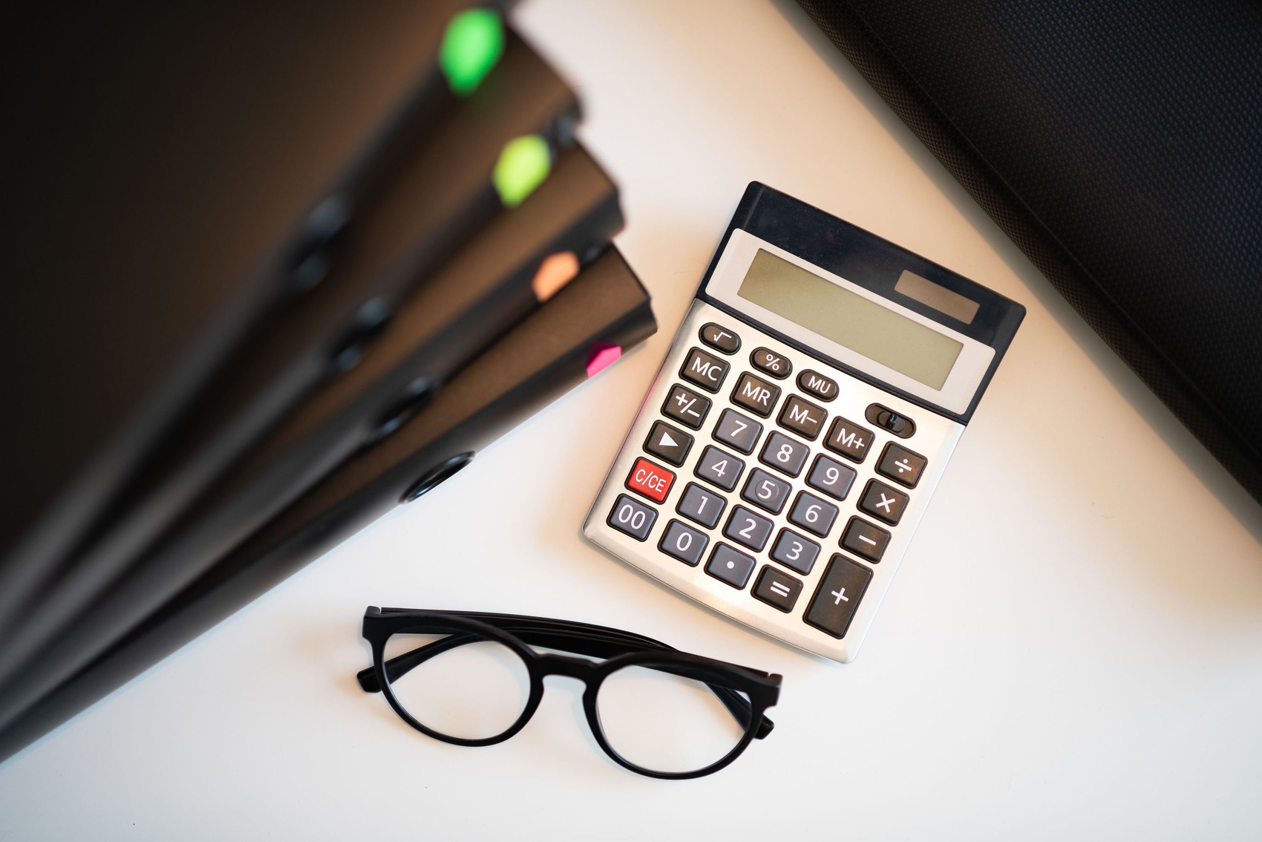 Calculatrice avec lunettes et dossiers sur un bureau