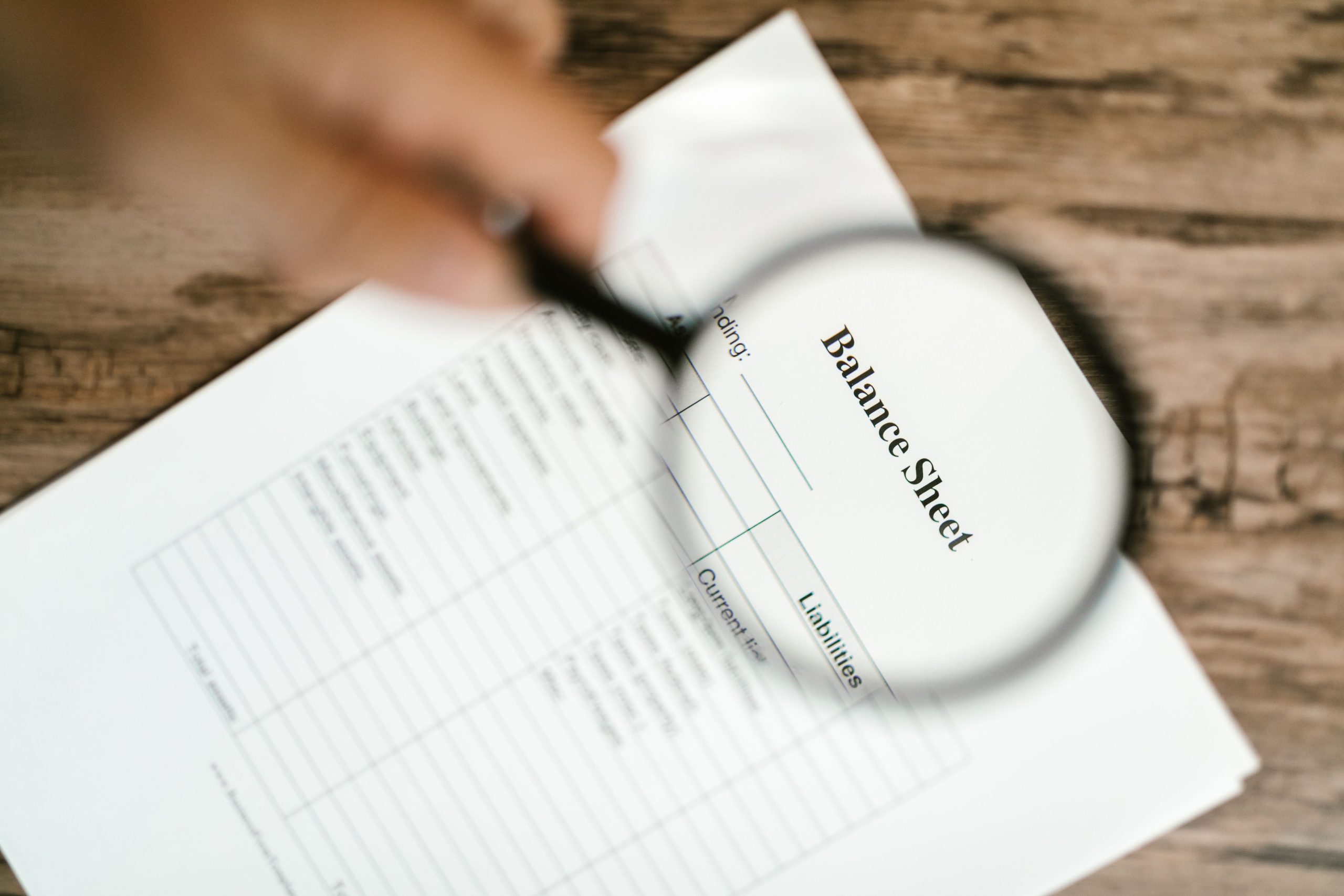 Bilan financier observé avec une loupe en bois