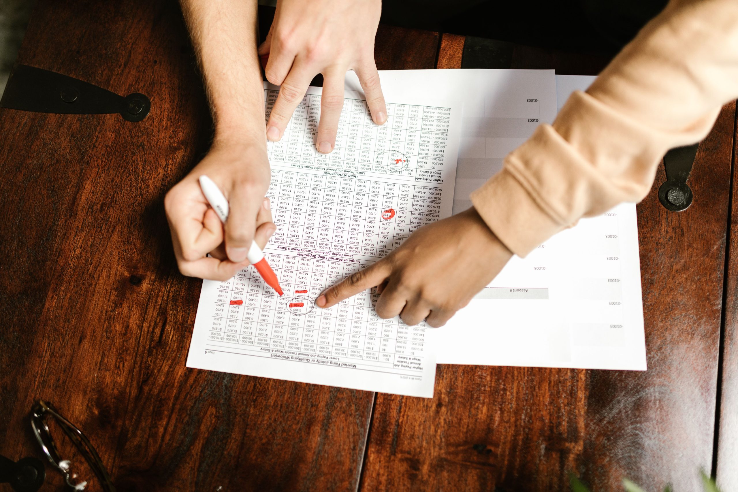 Deux mains vérifiant des documents comptables